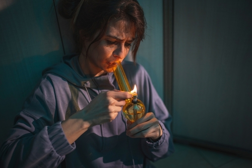 woman smoking weed out of a bong, why she might still feel high after 4 days of using weed