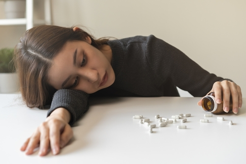 is vyvanse addictive? woman laying on counter with pills around her