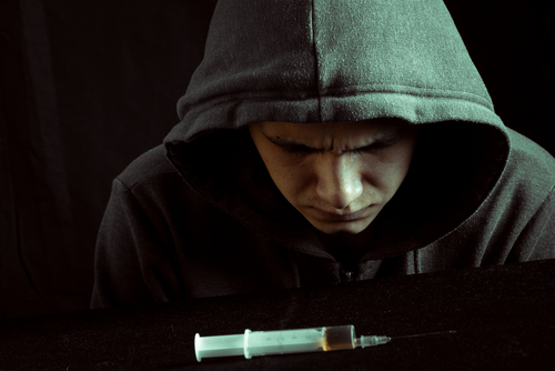 person looking down at a heroin needle about to go to detox for heroin abuse