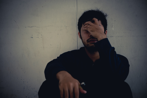 man sitting down with head in his hands after crack withdrawal