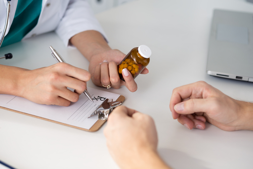 doctor prescribing pills to patient