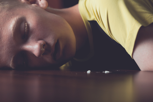 woman laying down with drugs around her